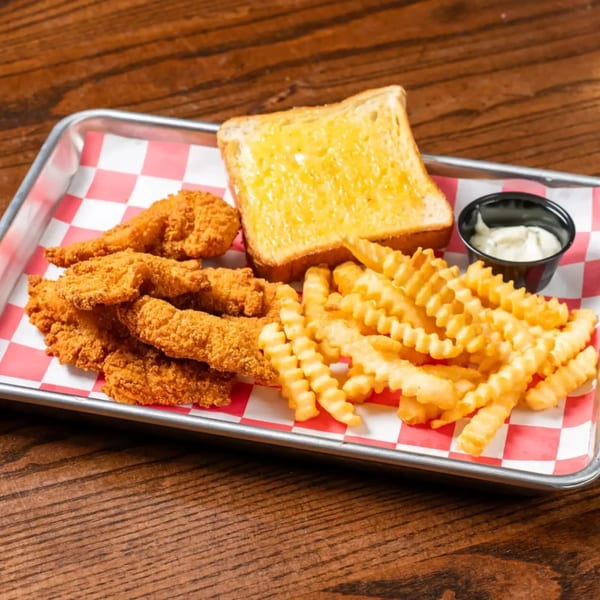 A metal tray with red and white checkered paper holds fried chicken tenders, crinkle-cut fries, and Texas toast.